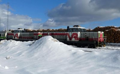 Partly-hidden by drifting snow, several centre-cab diesel locomotives await their next turn of duty.